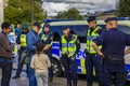 Group of uniformed Swedish male police officers talking to a little dark haired child in the center of Stockholm Sweden