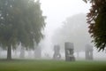 group of unique sculptures emerging from the mist in a park