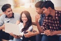 Group of university students smiling as they use laptop computer