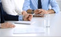 Group of unknown business people discussing questions at meeting in modern office, close-up of hands. Managers at