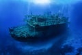 A group of unrecognizable divers explore a sunken shipwreck Royalty Free Stock Photo