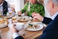 Group of unrecognizable senior friends at dinner party at home, eating. Royalty Free Stock Photo