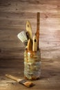 Group of used paint brushes in a plastic can on a rustic background in retro style Royalty Free Stock Photo