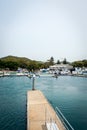 Luxury yachts and fishing boats parked with a concrete walkway at pier of Nelson Bay Royalty Free Stock Photo