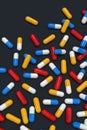 Colorful medicine capsules on dark background