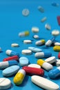 Group of various medicine pills falling on blue surface Royalty Free Stock Photo