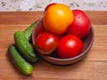 A group of tomatoes and cucumbers on the table.