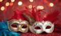 A group of Venetian or Mardi Gras masks on a dark, glittery surface with a bokeh light effect in the background. Royalty Free Stock Photo