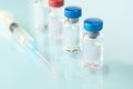 Group of vials with medication and syringe on table, blue background. Copy space Royalty Free Stock Photo