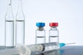 Group of vials with medication and syringe on table, blue background. Copy space Royalty Free Stock Photo