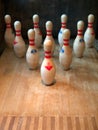 Group of vintage bowling pins with red stripes on a wooden floor Royalty Free Stock Photo