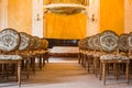 A group of vintage wooden chairs stands in several rows in a large old room with a luxurious interior. empty auditorium in the