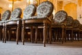 A group of vintage wooden chairs stands in several rows in a large old room with a luxurious interior. empty auditorium in the