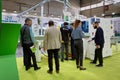 A group of visitors and an engineer discuss the operation of woodworking equipment