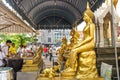 Group of visitors in front of golden statues of Lord Buddha