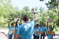 Group of volunteer protest against earth pollution and global warming. Back of head leader standing and raising fists up to cheer