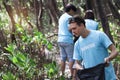 Group of volunteers in blue t-shirt hold garbage bag, ecology people cleaning and picking up trash to reduce land pollution Royalty Free Stock Photo