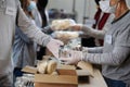 Group of volunteers in community donation center, food bank and coronavirus concept.