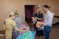 Group of volunteers donating clothes for babies to young mother in the maternity home during children protection day