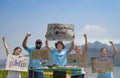 group of volunteers holding environmental campaign signs standing by the river