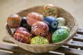 Group of wax painted Easter eggs in light brown wicker basket Royalty Free Stock Photo