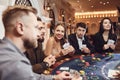 A group of wealthy young people gamble at a casino.