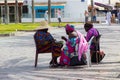 A group of West African sisters enjoy a well earned snack as the take a rest from their hair plaiting business for tourists on the