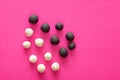 Group of white and black plasticine balls on pink vibrant background. Concepts of racism, group separated representing intolerance Royalty Free Stock Photo