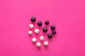 Group of white and black plasticine balls on pink vibrant background. Concepts of racism, group separated representing intolerance Royalty Free Stock Photo