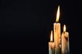 Group of white candles burning in the dark