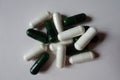 Group of white capsules of magnesium citrate and green capsules of multivatamins