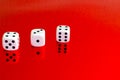 Closeup of a group of white dice on a red reflective surface Royalty Free Stock Photo