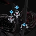 Group of white gold rings and earrings with topaz, garnets and diamonds on natural roses black background Royalty Free Stock Photo