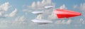 A group of white paper air planes heading in one direction lead by red individual paper plane as a business industry icon for Royalty Free Stock Photo