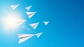 group of white paper airplanes soaring through a bright blue Royalty Free Stock Photo