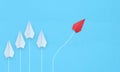 Group of white paper planes in one direction and one red paper plane pointing in different way on blue background. Business for Royalty Free Stock Photo