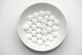 Group of white pills in a plate on white background - healthcare and medicament concept. Pharmaceutical industry. Pharmacy