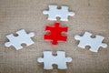 A group of white and red jigsaw puzzles placed on hemp sacks