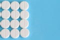 Group of white round pills on a blue background Royalty Free Stock Photo