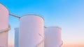 Group of white storage fuel tanks in petrochemical industrial area against beautiful dusk sky background Royalty Free Stock Photo