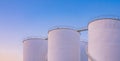 Group of white storage fuel tanks in petrochemical industrial area against dusk sky background in evening time Royalty Free Stock Photo