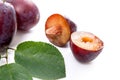 Group of whole and half of ripe plums with leaf isolated on a white background.. Royalty Free Stock Photo