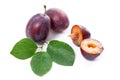 Group of whole and half of ripe plums with leaf isolated on a white background.. Royalty Free Stock Photo