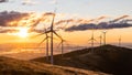 A group of wind mills on a mountain ridge in front of a morning