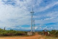 Group of Wind power stations side view on blue sky background Royalty Free Stock Photo