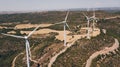 Group of wind turbines at a wind farm on a hill with some fields in summer. Ecology concept Royalty Free Stock Photo