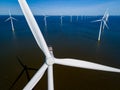 A group of windmills floats gracefully on top of tranquil waters in the Netherlands Flevoland, Royalty Free Stock Photo