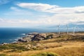 A group of windmills generating renewable energy on a scenic hill overlooking the ocean, View from Cape Kaliakra to an offshore