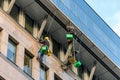 Group of window cleaners hanging from ropes cleaning the facade of a building in Budapest, Hungary