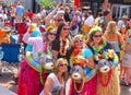 Group of women in front of crowd posing for picture before a Jimmy Buffet concert with silly tropical costumes grass skirts and dr